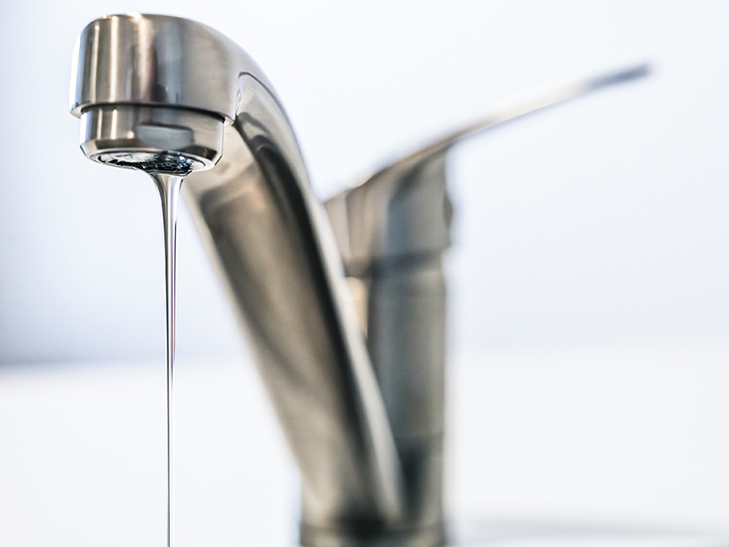 Bathroom faucet with water slowly dripping due to low water pressure